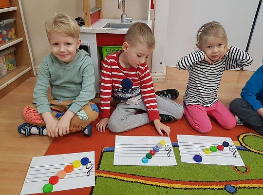 Dzieci układają zakrętki na pięciolinii