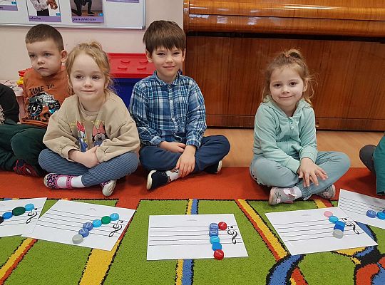 Dzieci układają zakrętki na pięciolinii