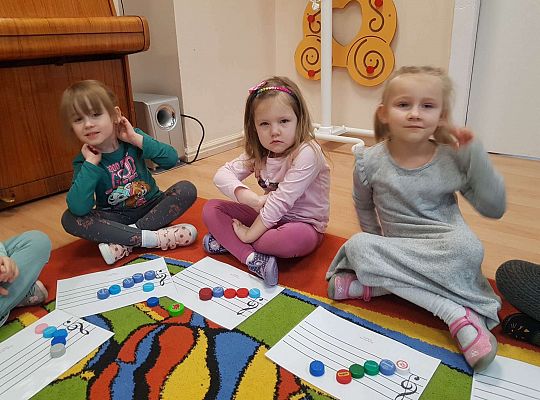 Dzieci układają zakrętki na pięciolinii