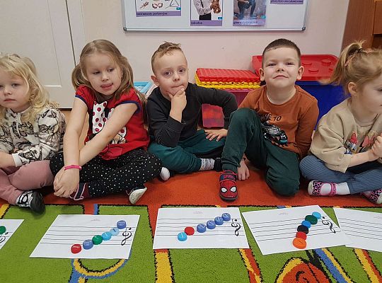 Dzieci układają zakrętki na pięciolinii