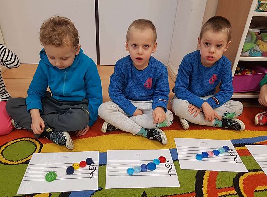 Dzieci układają zakrętki na pięciolinii