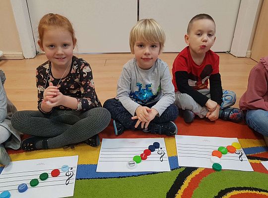 Dzieci układają zakrętki na pięciolinii