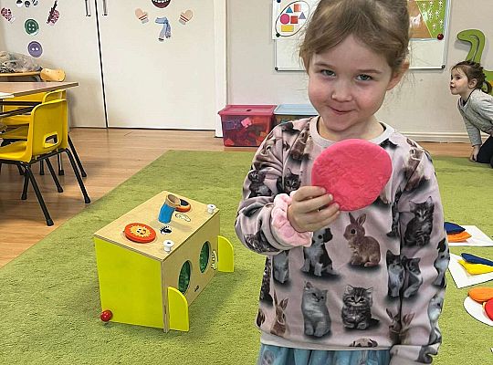 Dzieci pokazują wylosowaną figurę geometryczną