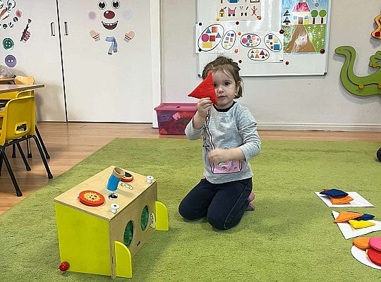 Dzieci pokazują wylosowaną figurę geometryczną