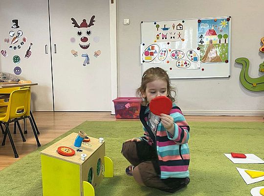 Dzieci pokazują wylosowaną figurę geometryczną