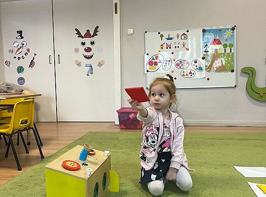 Dzieci pokazują wylosowaną figurę geometryczną