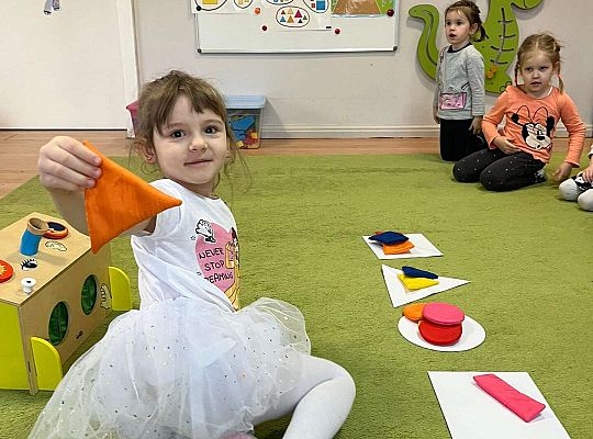 Dzieci pokazują wylosowaną figurę geometryczną