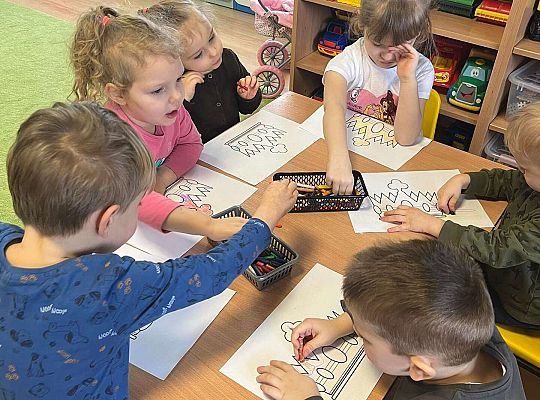 Dzieci kolorują prezent dla jubilatki