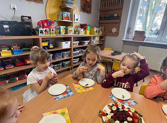 Dzieci jedzą urodzinowe owoce