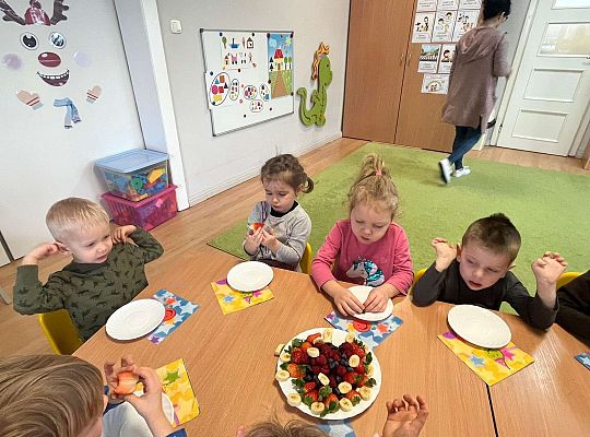 Dzieci jedzą urodzinowe owoce