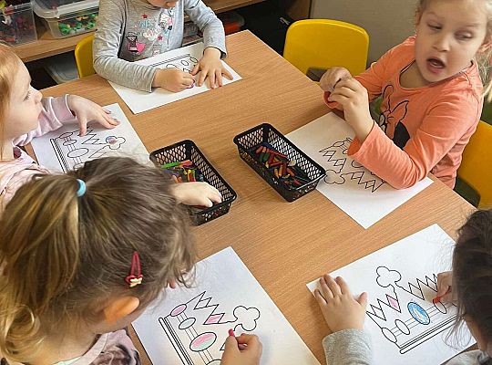 Dzieci kolorują prezent dla jubilatki