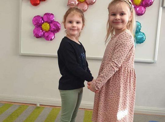 Dziewczynka trzyma za ręce solenizantkę