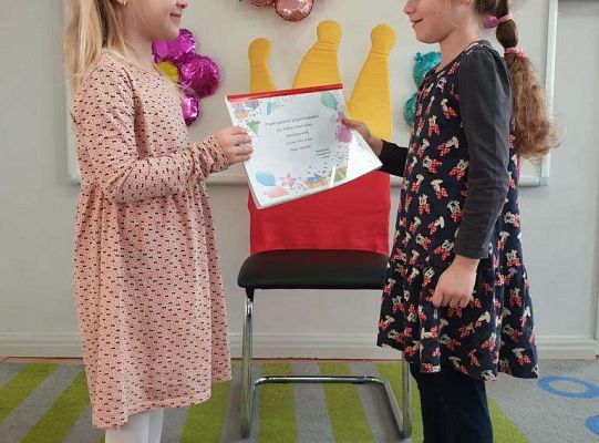 Dziewczynka wręcza album urodzinowy solenizantce