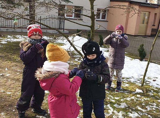 Dzieci przygotowują karmę dla ptaków do powieszenia na drzewach