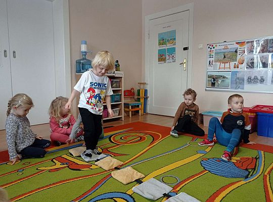 Dzieci przechodzą po ścieżce sensorycznej