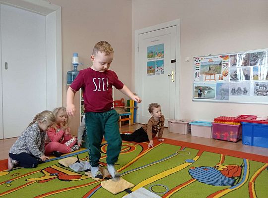 Dzieci przechodzą po ścieżce sensorycznej