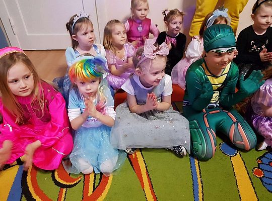 Dzieci siedzą na dywanie