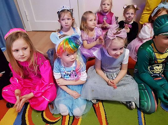 Dzieci siedzą na dywanie