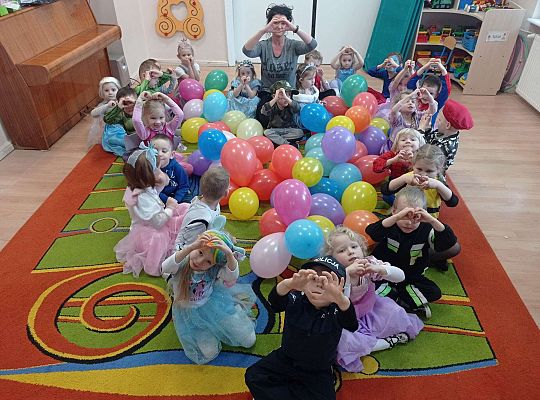 Dzieci siedzą na dywanie w kształcie serca