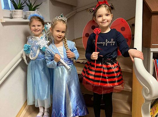 Dziewczynki stoją na schodach w strojach karnawałowych