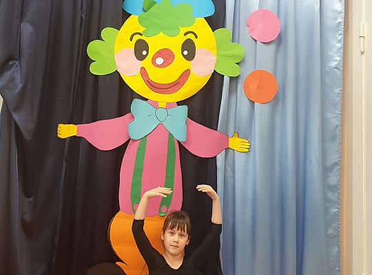 dziewczynka robi szpagat przed klaunem