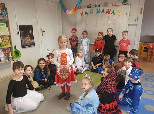 Grupa dzieci siedzi na dywanie