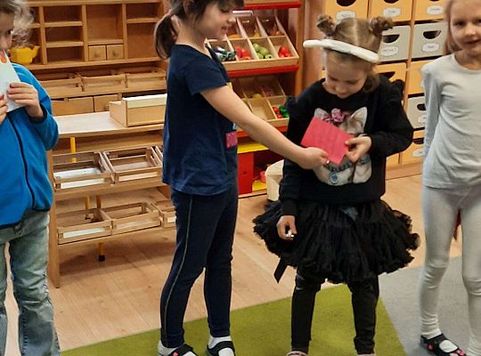 Dzieci wręczają sobie kartki walentynkowe