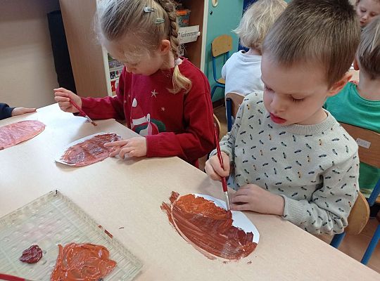 Dzieci malują farbami pączki z papieru