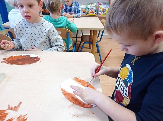 Dzieci malują farbami pączki z papieru