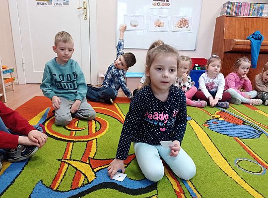 Dzieci przeliczają pączki na dywanie