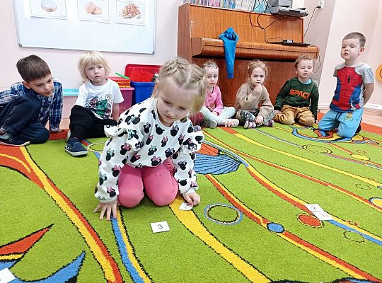 Dzieci przeliczają pączki na dywanie