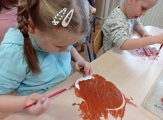 Dzieci malują farbami pączki z papieru