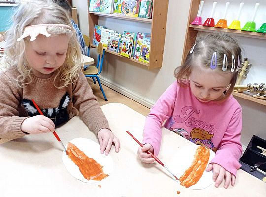 Dzieci malują farbami pączki z papieru