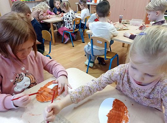 Dzieci malują farbami pączki z papieru