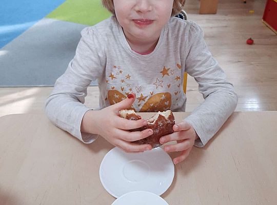 Dziewczynka je pączka