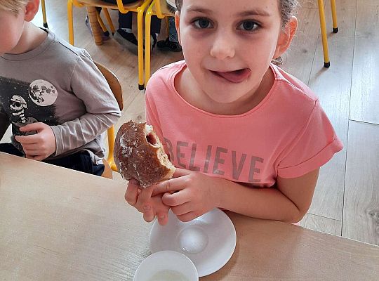 Dziewczynka je pączka