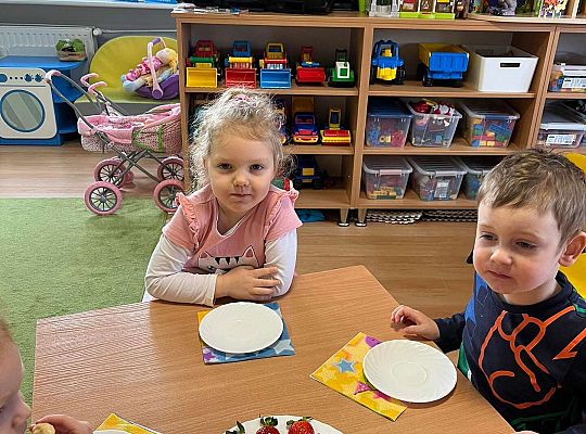 Dzieci jedzą urodzinowe owoce