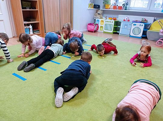 Dzieci dmuchają przez słomki popychając karteczki