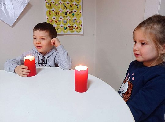 Dzieci dmuchają na świeczkę tak aby ogień nie zgasł tylko tańczył