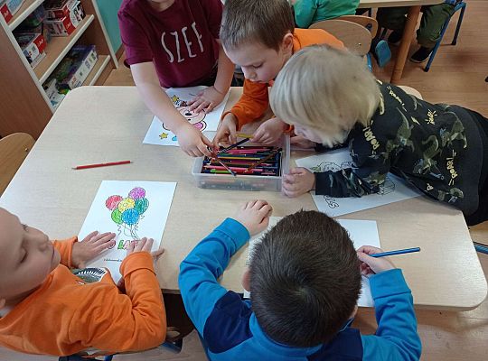 Dzieci kolorują obrazki do urodzinowego albumu