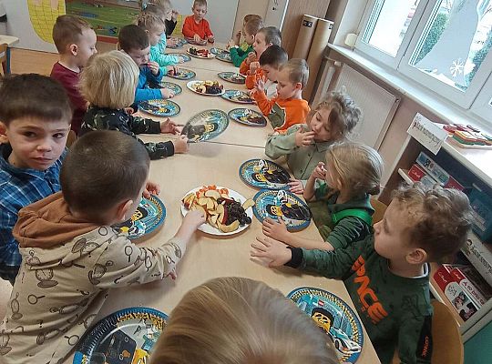 Dzieci jedzą urodzinowe owoce