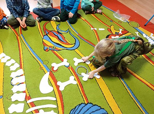 Dzieci układają szkielet dinozaura