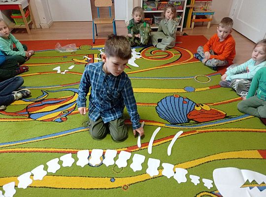 Dzieci układają szkielet dinozaura