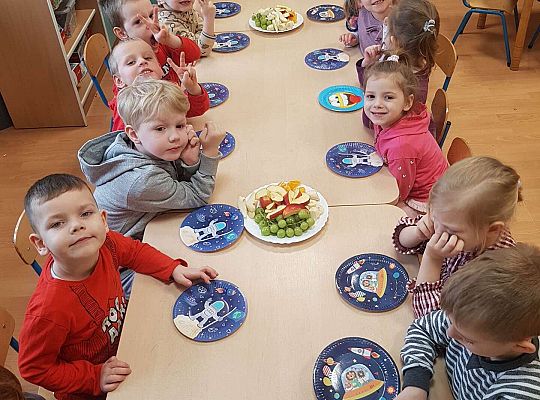 Dzieci jedzą urodzinowe owoce