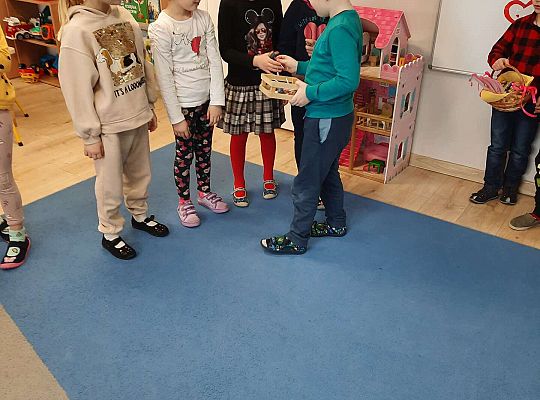 Chłopiec wręcza dziewczynkom prezenty