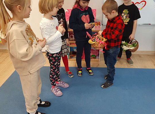 Chłopiec wręcza dziewczynkom prezenty