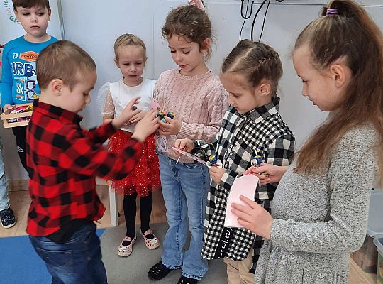 Chłopiec wręcza dziewczynkom prezenty