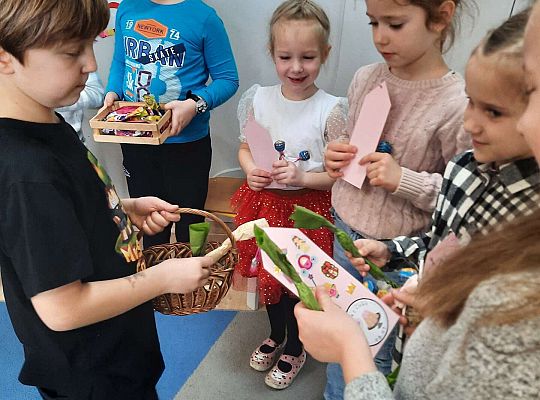 Chłopiec wręcza dziewczynkom prezenty