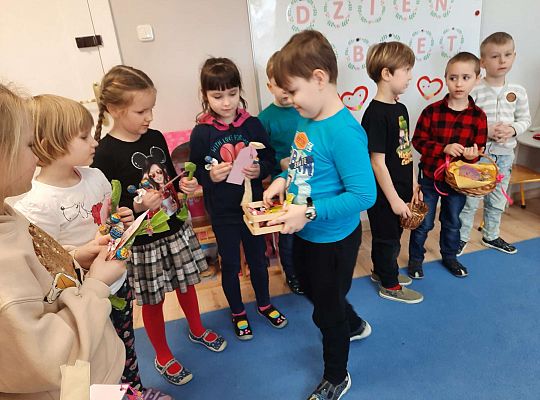 Chłopiec wręcza dziewczynkom prezenty