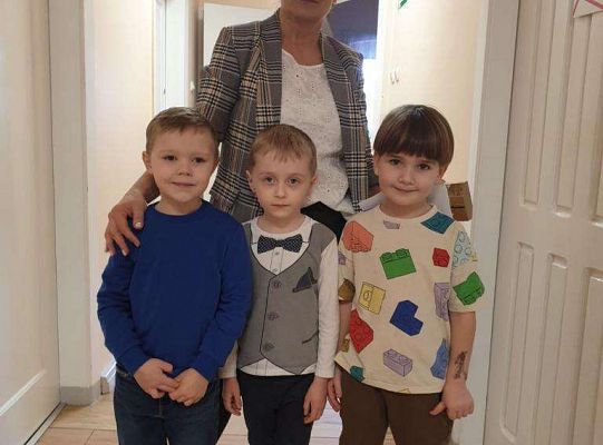 Pani Dyrektor stoi z trzema chłopcami